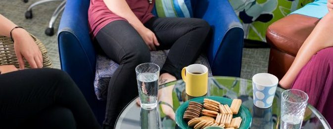 women sitting around a coffee table 