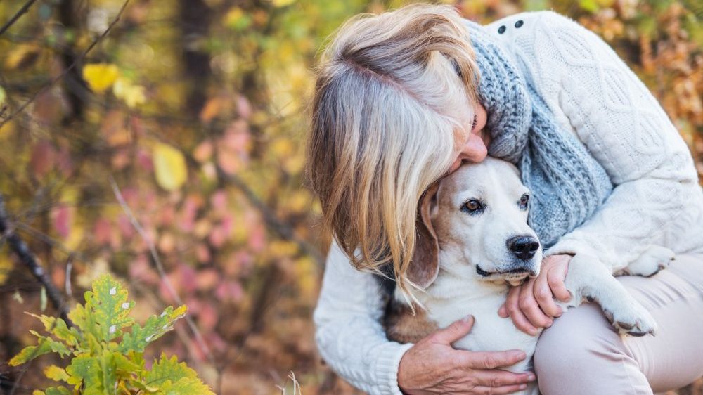 Older woman cuddling her older dog