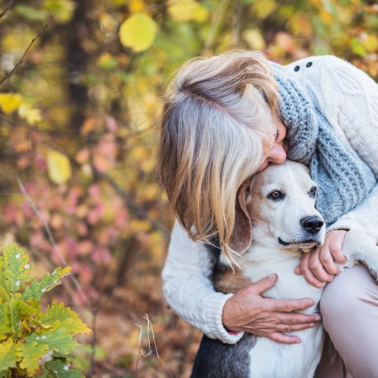 Older woman cuddling her older dog