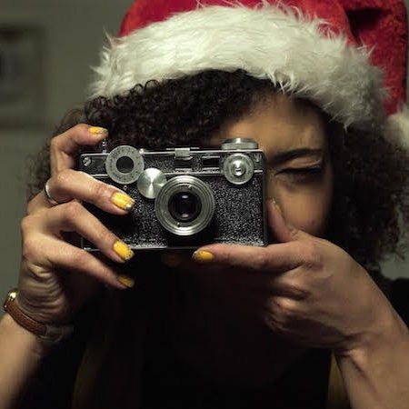 woman in santa hat taking photo