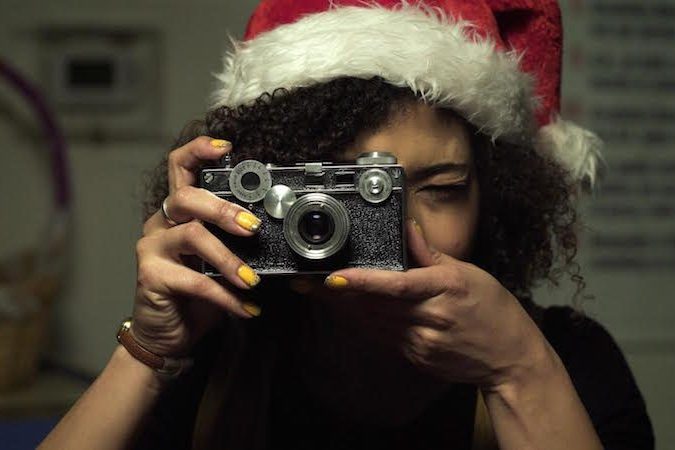 woman in santa hat taking photo