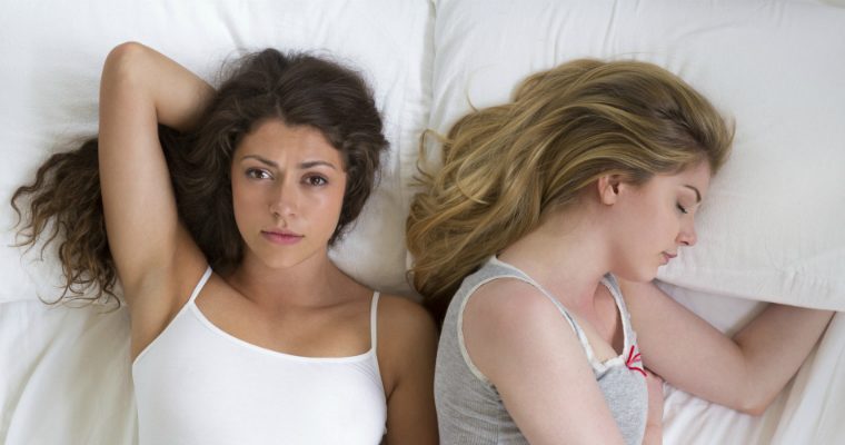 2 women lying in bed 
