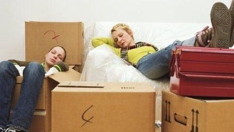 2 women sitting amongst boxes