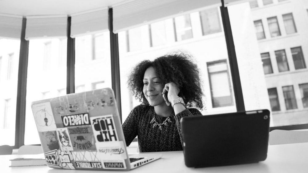 women of colour smiling at laptop