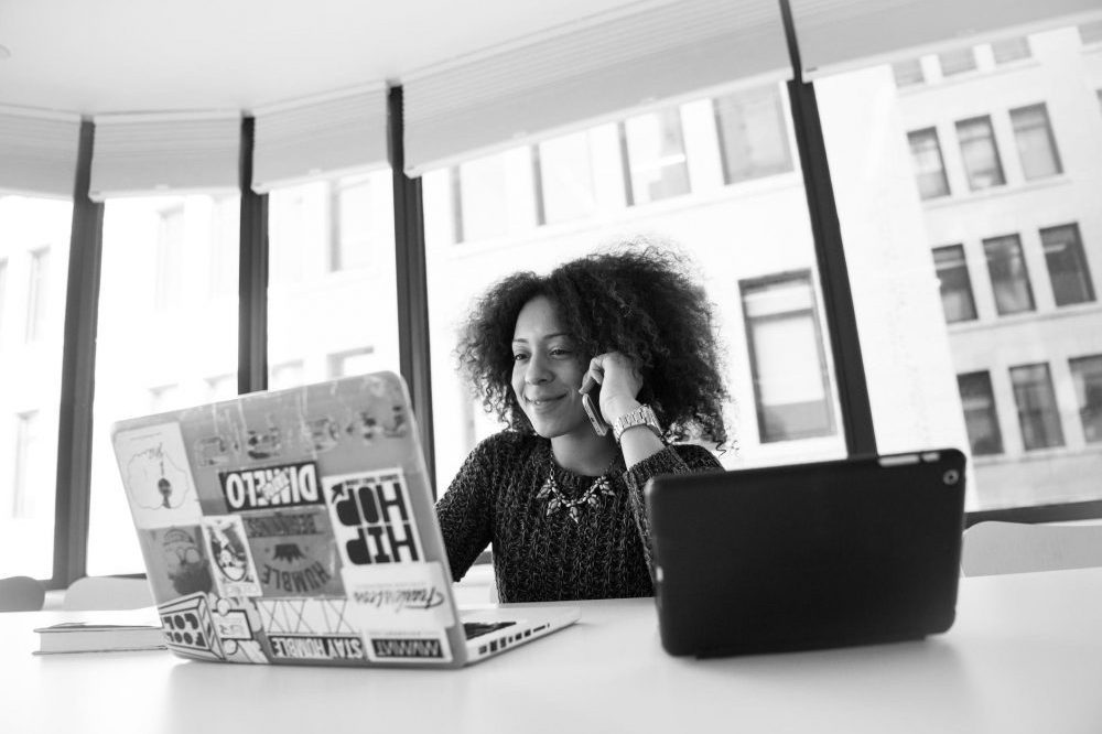 women of colour smiling at laptop