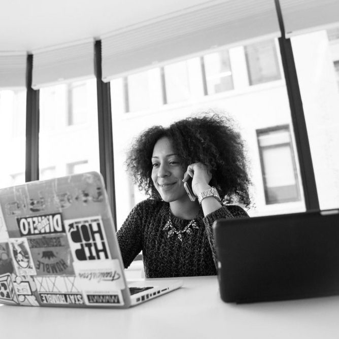 women of colour smiling at laptop