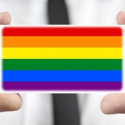 person holding small rainbow badge