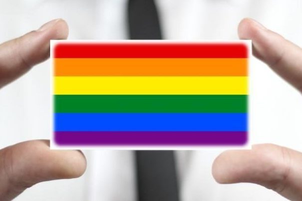 person holding small rainbow badge