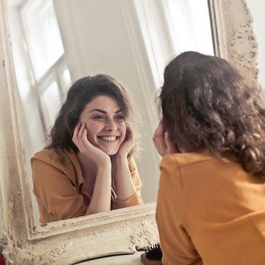 woman looking into mirror smiling