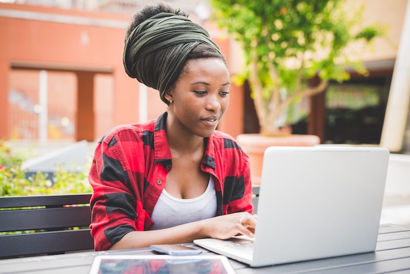 Woman of Colour typing on laptop