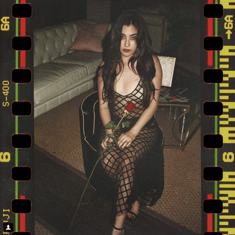 Lauren Jauregui sitting on chair holding a red rose