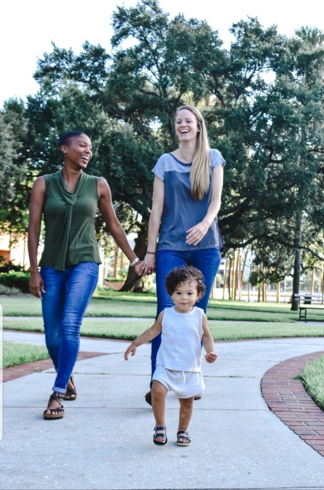 Lesbian couple walking in park with toddler