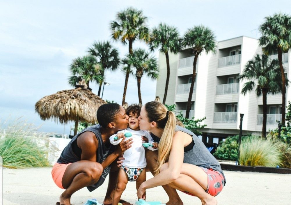 lesbian parents kissing toddlers cheeks