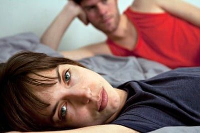 Unhappy couple lying in bed