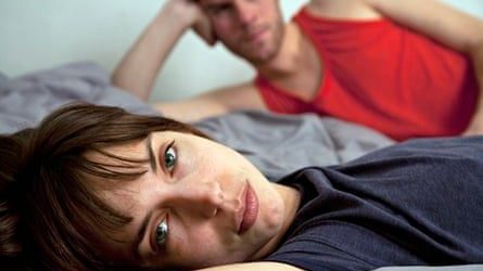 Unhappy couple lying in bed