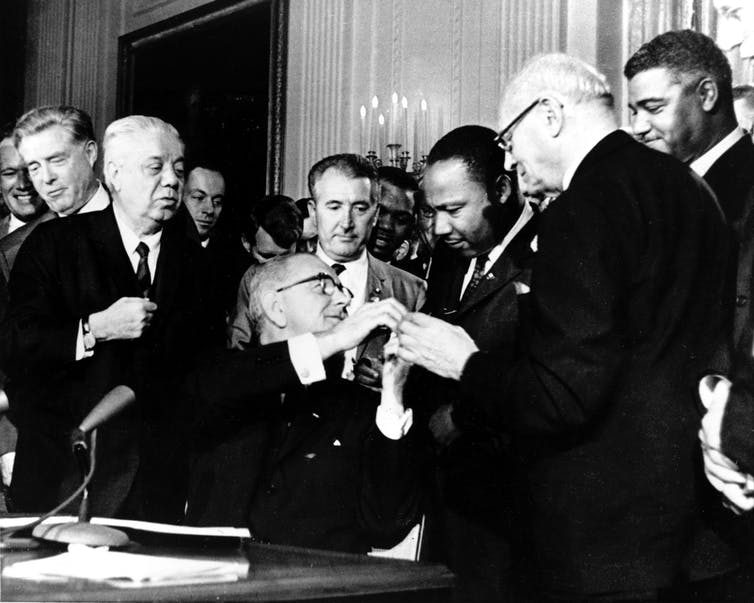 Lyndon B. Johnson presents Martin Luther King Jr. with one of the pens used to sign the Civil Rights Act. AP Photo