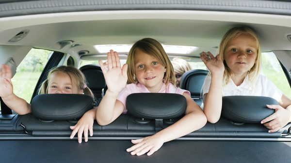 3 young children in back of a car