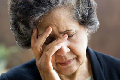 Older Hispanic woman resting her head on her hand