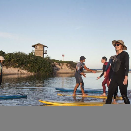 women standing on surf boards