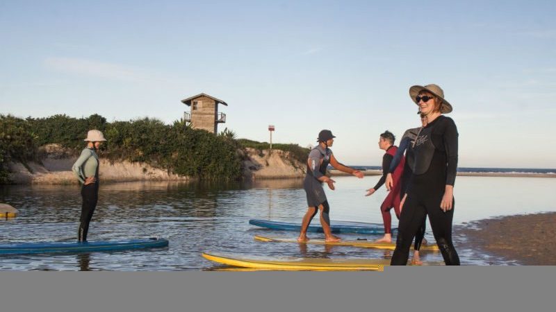 women standing on surf boards