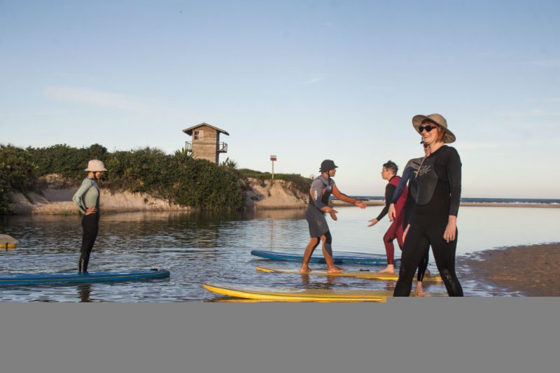 women standing on surf boards