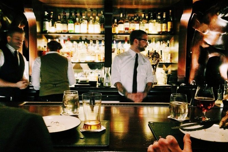 Male bartender behind a bar