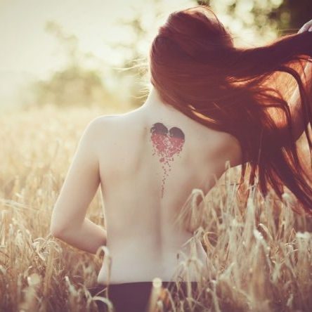 woman from behind with love heart tatoo on her back