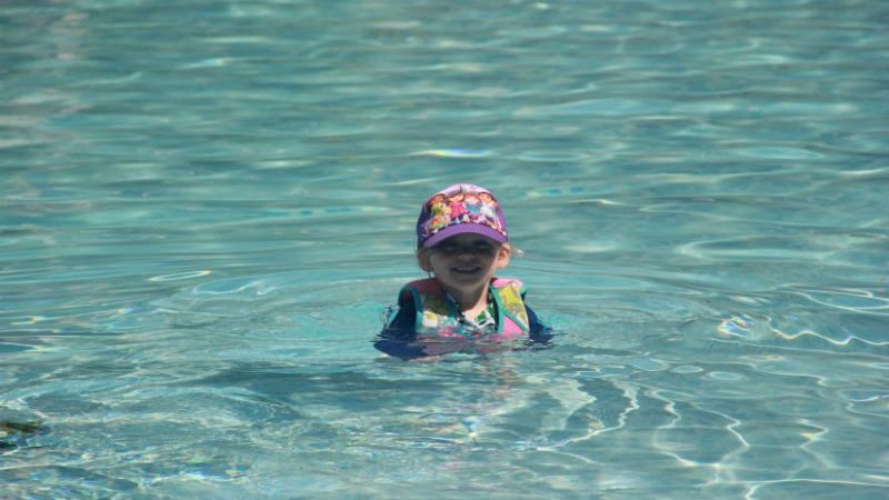 child swimming in pool