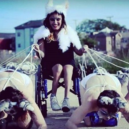 Woman in a wheelchair being pulled by 4 other women