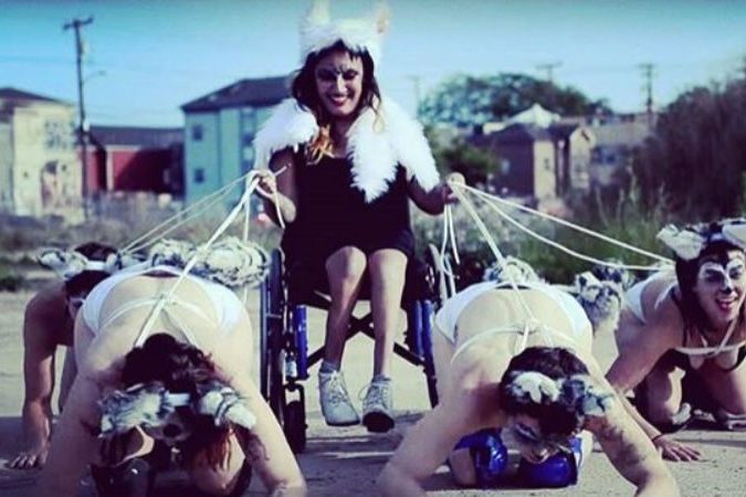 Woman in a wheelchair being pulled by 4 other women