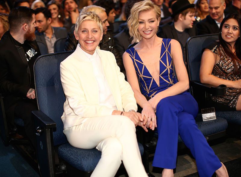 Ellen degeneres and Portia de rossi holding hands sitting down 