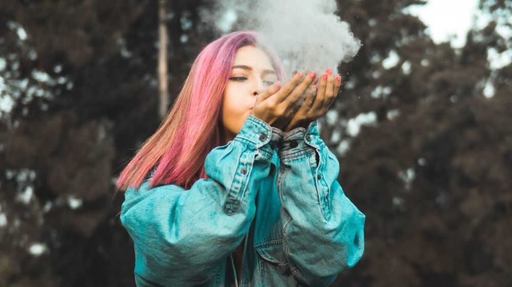 women blowing dust