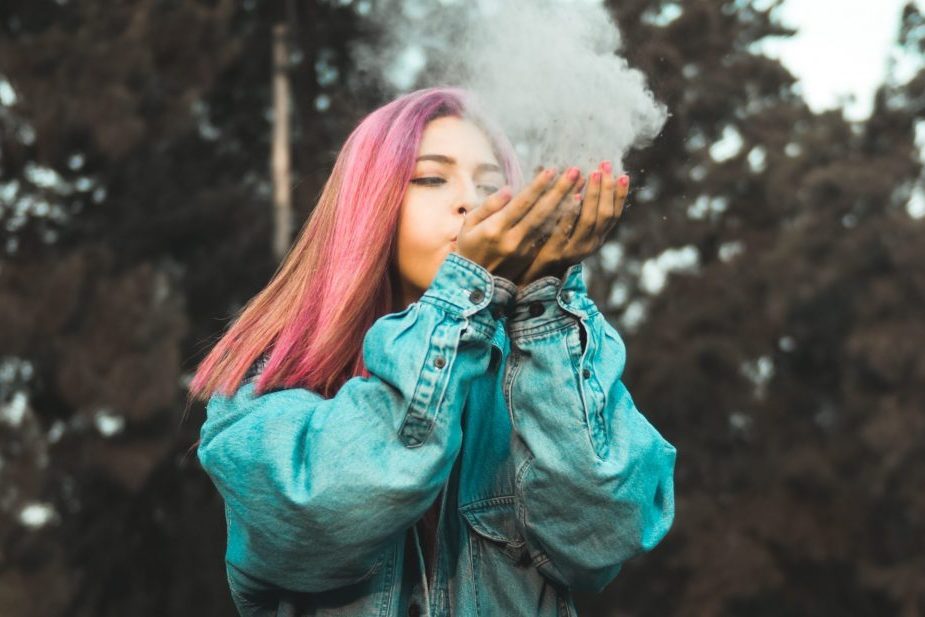 women blowing dust