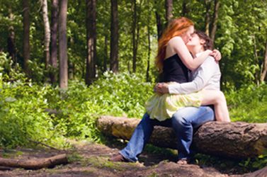 2 women kissing in forest