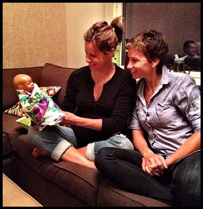 Jenna Wolfe and her partner Stephanie Gosk holding their baby