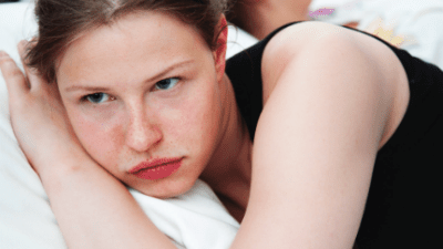 2 women in bed lying back to back