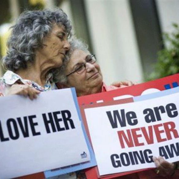 2 older Lesbians holding up signs