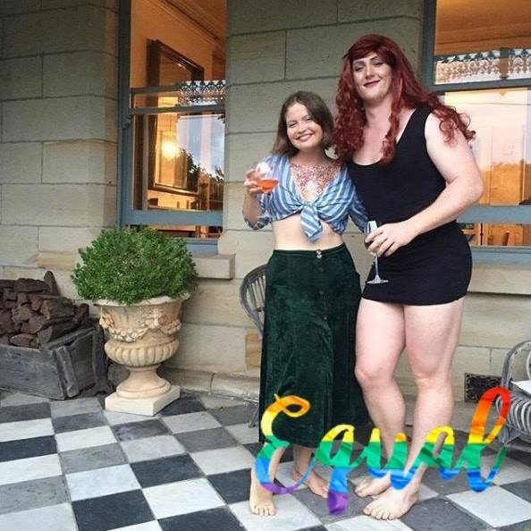 transgender and woman posing with glass of wine