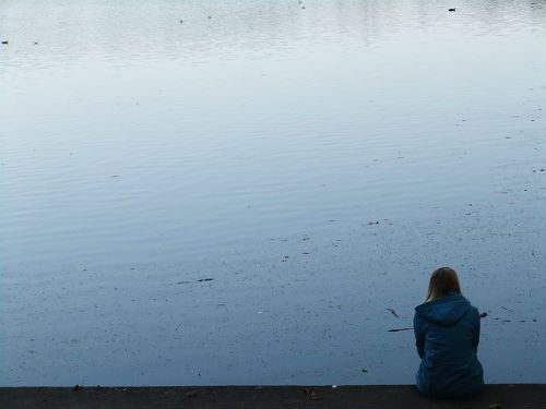 woman from behind sitting on lake