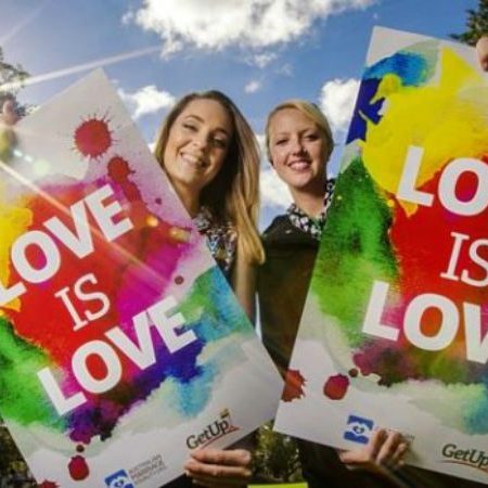 2 Women holding up poster 