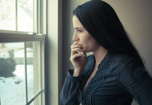 dark haired woman looking out the window