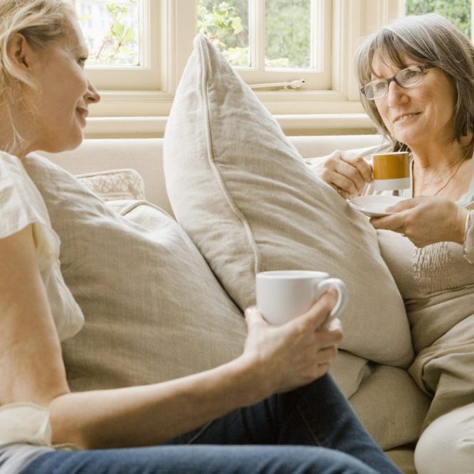 Older and younger woman talking on sofa