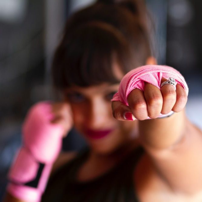 Woman in boxing position with pink gloves