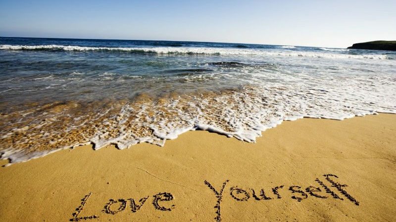 Words written into the sand 'Love Yourself'