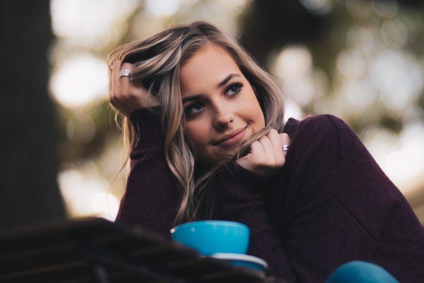 Young woman smiling over cup of coffee