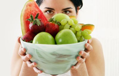 woman holding bowl of fruit 