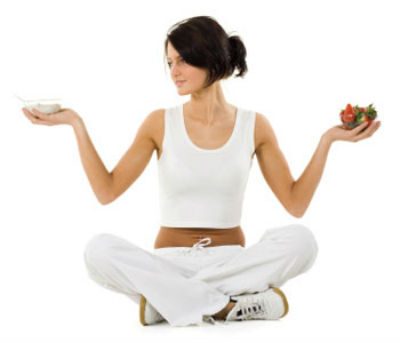 woman in white holding up a bowl of fruit 