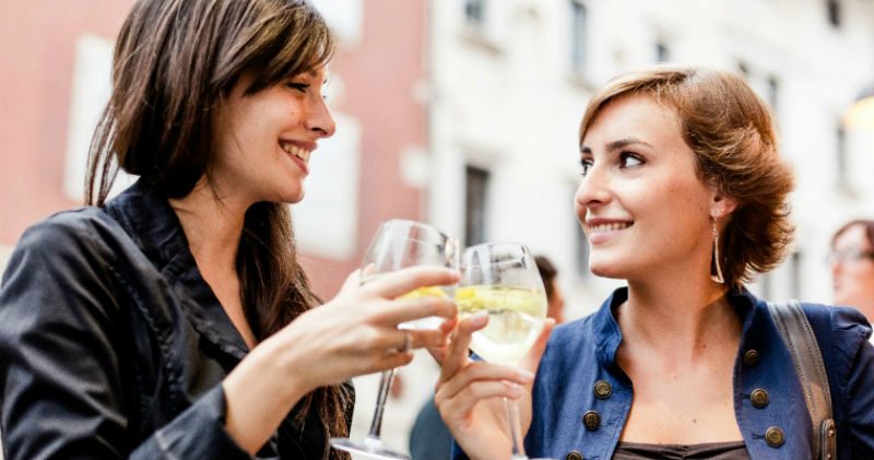 2 women drinking out of wine glass