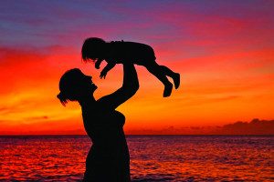 Mother holding a toddler up in the air