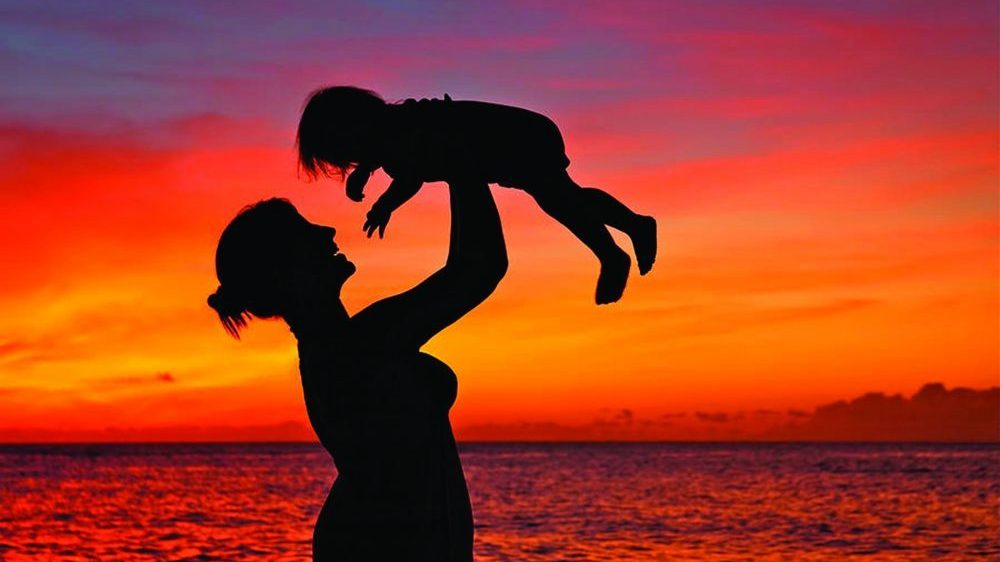 Mother holding a toddler up in the air